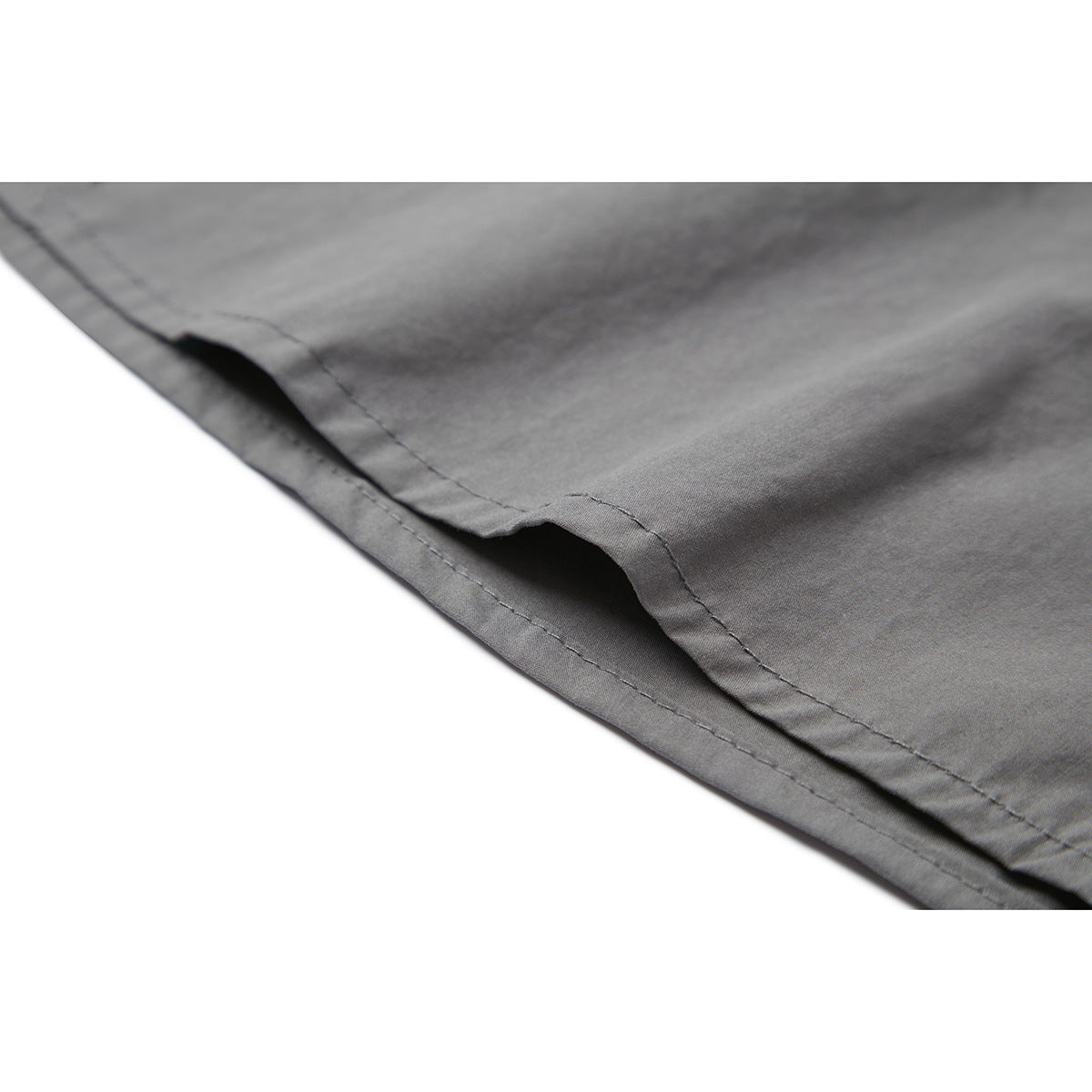 Close-up of the gray shirt’s stitched hem and folded edge.
