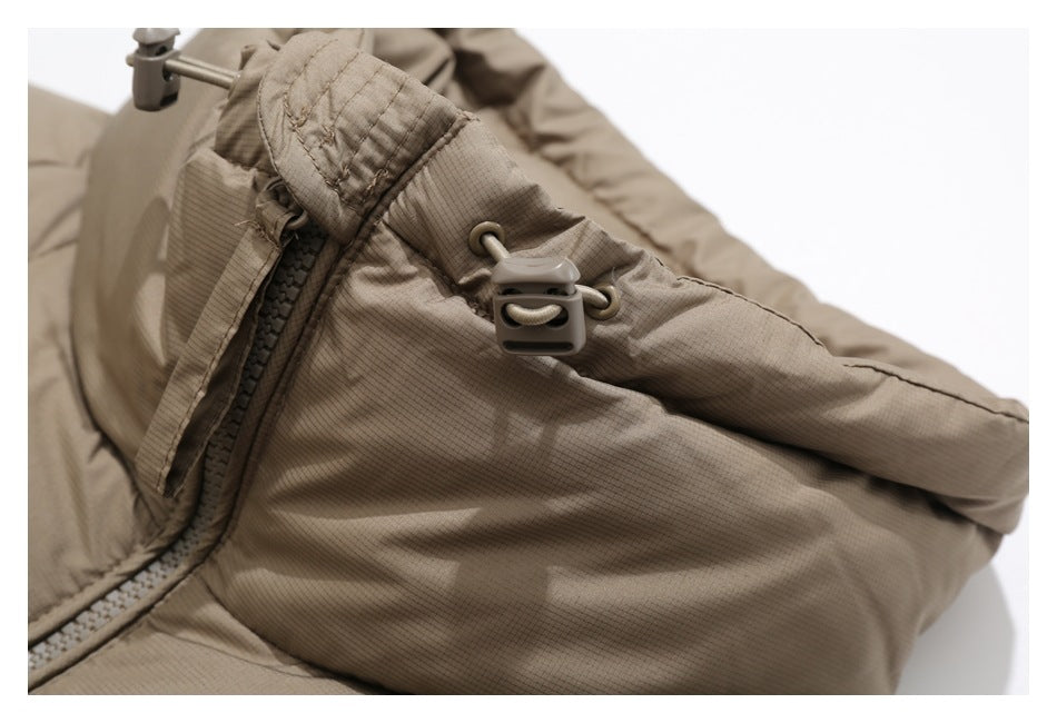 Close-up of the taupe jacket’s collar drawcord toggle, stitching and zipper.