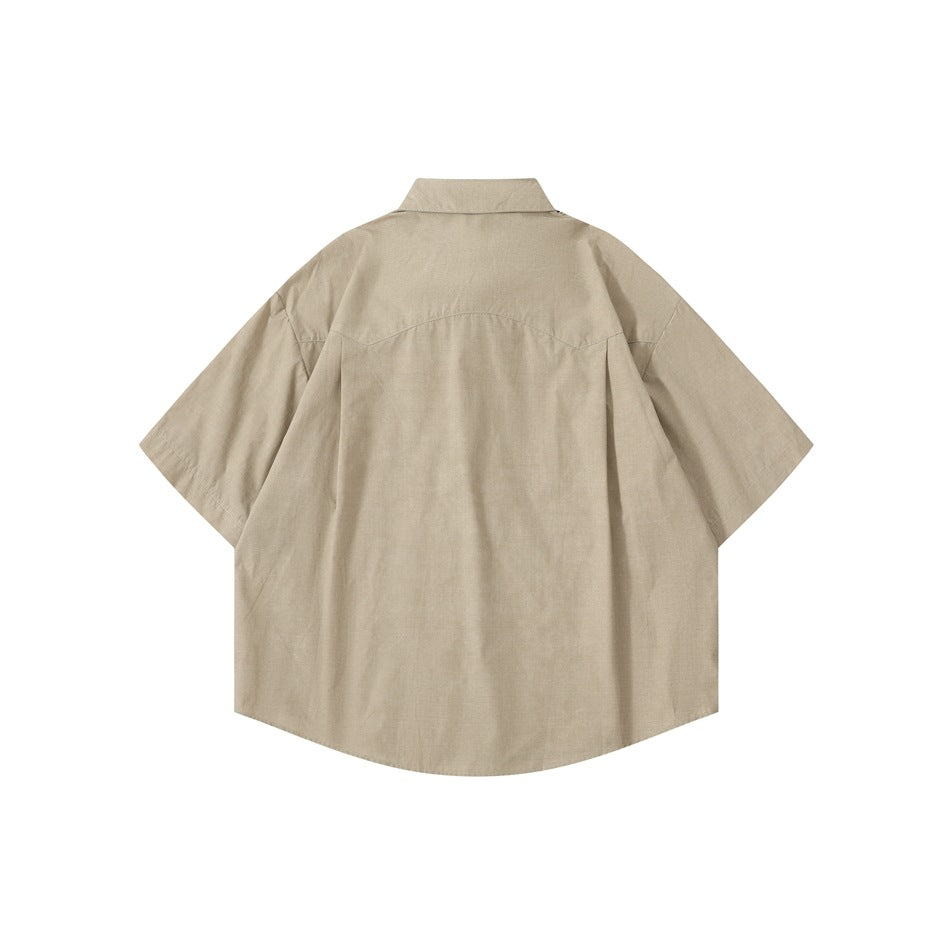 Back view of a beige short-sleeve button-up shirt with a curved hem and back yoke seam.