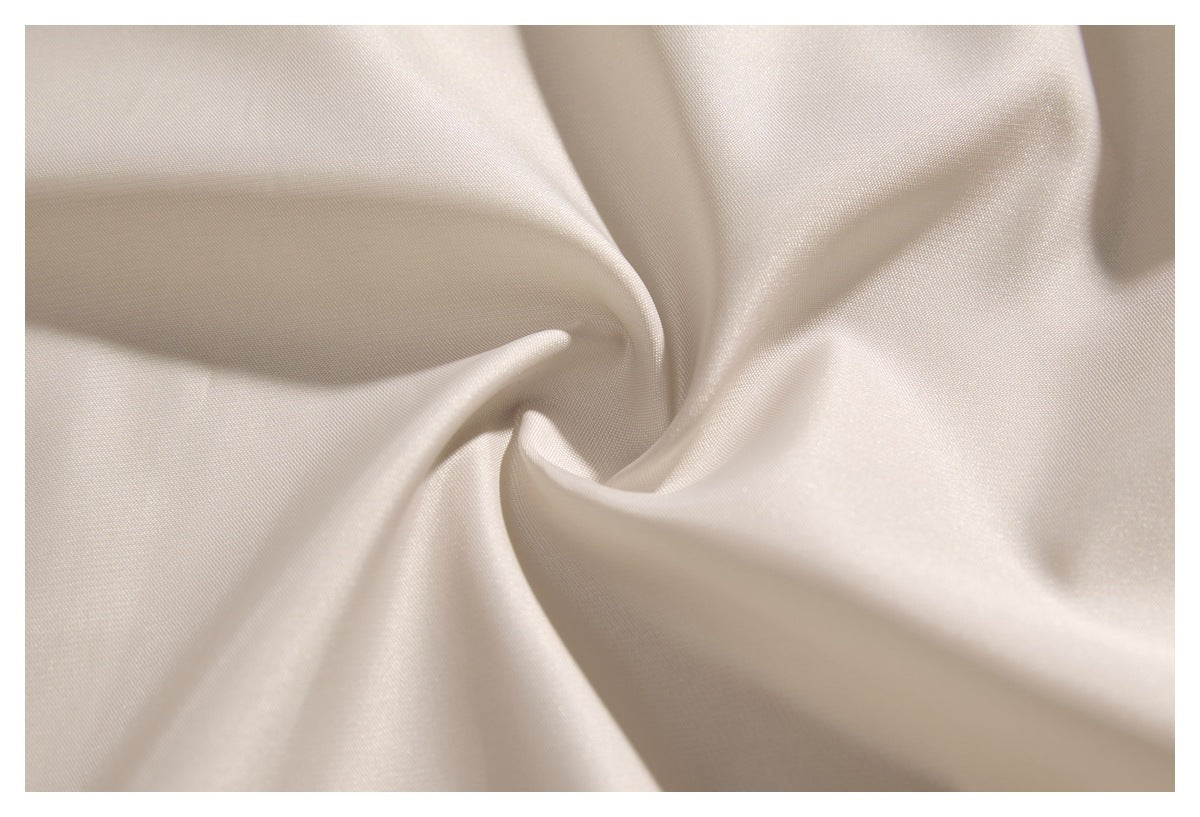 Close-up of smooth ivory fabric gathered into soft folds.
