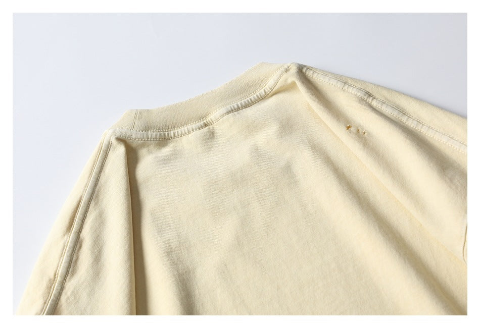 Close-up of a pale cream shirt's shoulder and ribbed neckline seam.