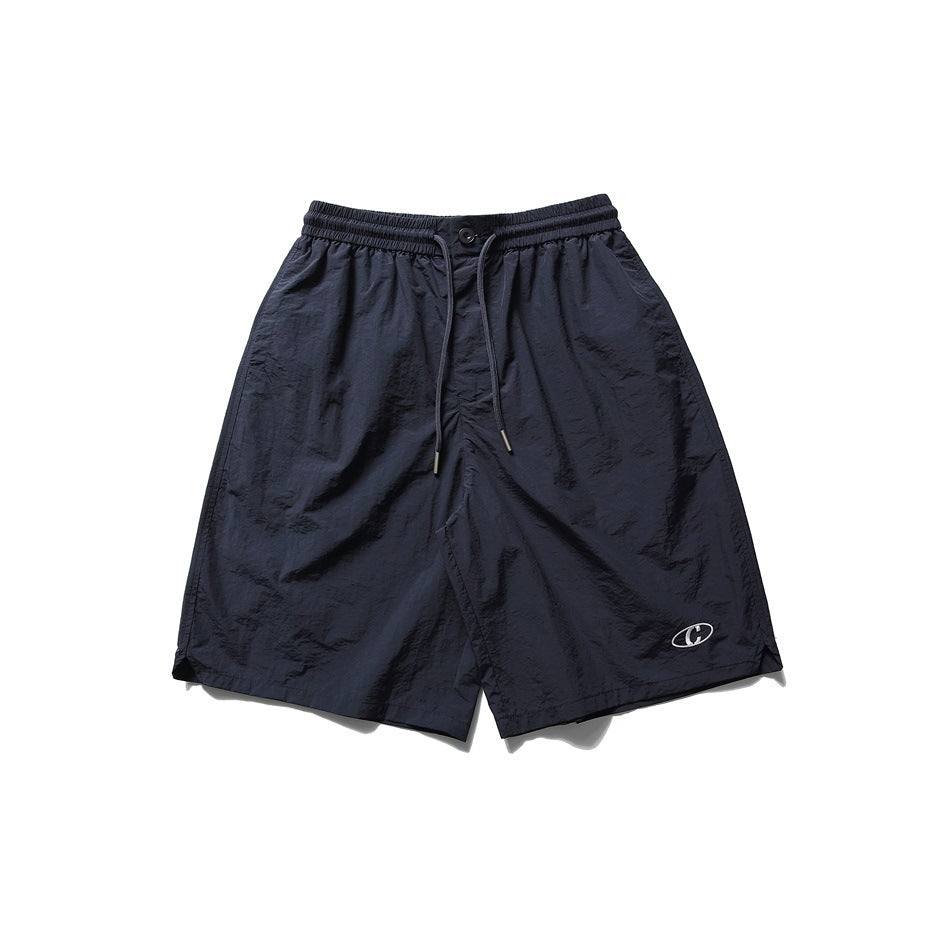 Navy knee-length drawstring shorts with elastic waist and small embroidered oval logo, flat front view