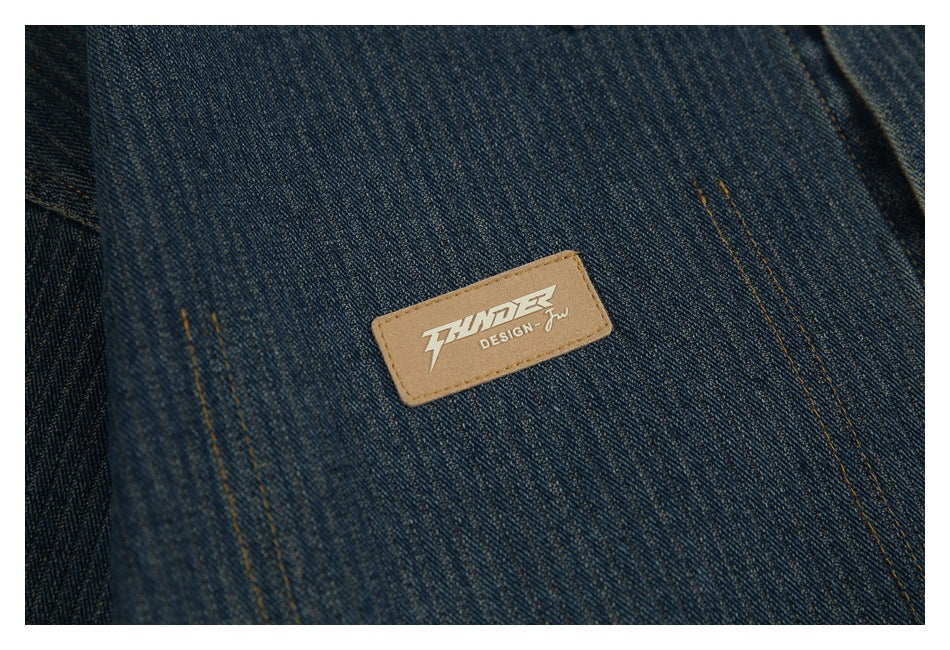 Close-up of a tan rectangular brand patch stitched onto dark blue denim.