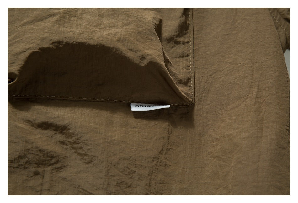Close-up of a brown garment pocket edge with a small white sewn label.