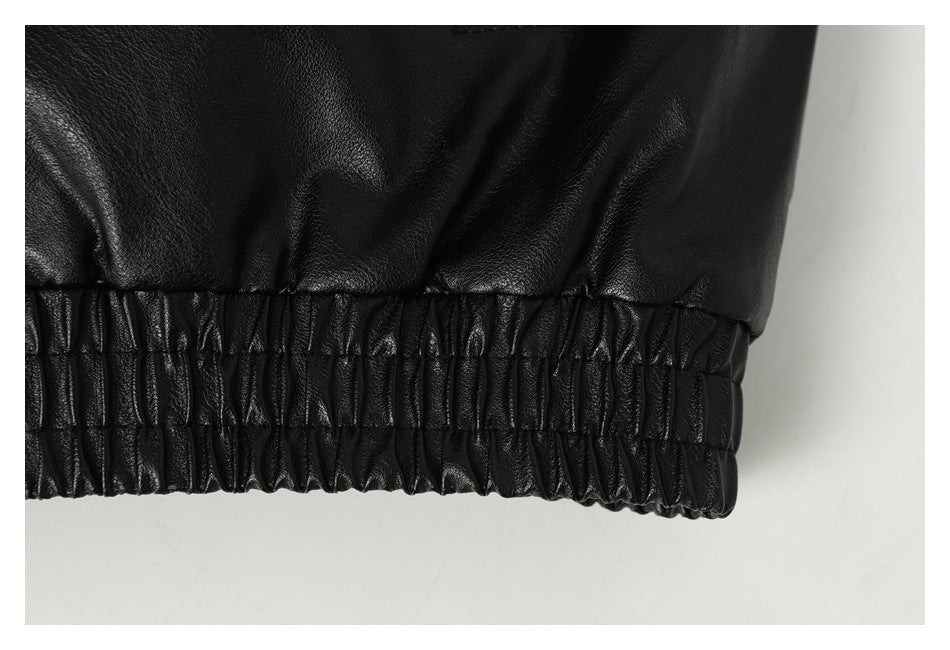 Close-up of the black jacket's gathered elastic hem.