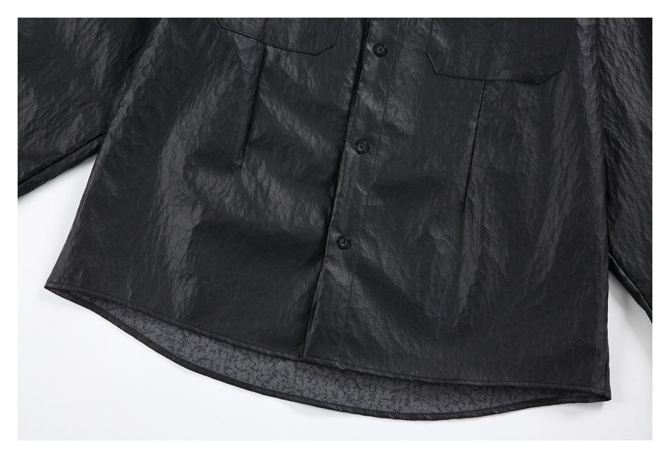 Close view of the black shirt's buttoned front, lower hem, and crinkled surface.