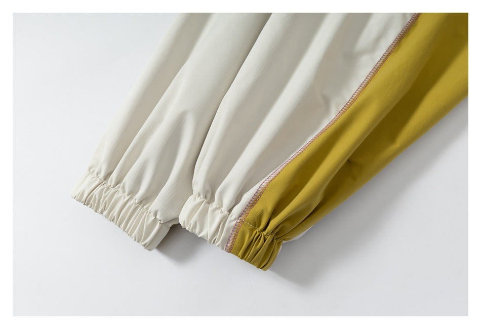 Gathered elastic cuffs on cream and mustard-yellow sleeves, joined by pink overlock stitching.