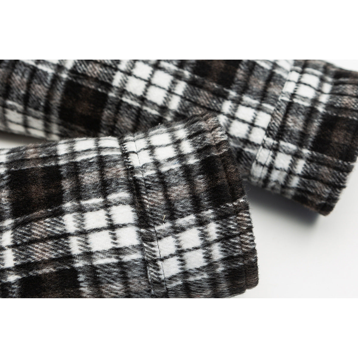 Close-up of the black-and-white plaid jacket sleeve and cuff seam.