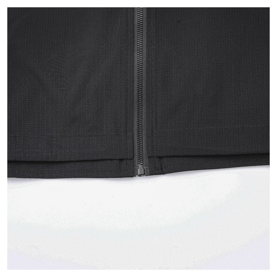 Close-up of a black garment's straight zipper ending at the stitched hem.