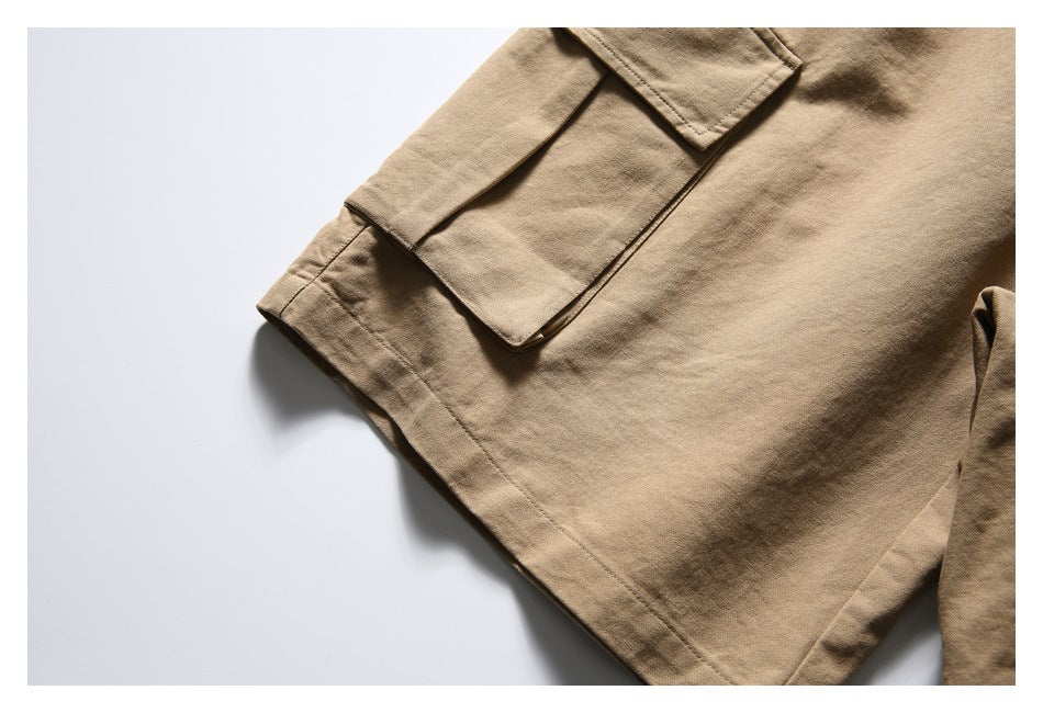 Close-up of a large flap cargo pocket and hem on the tan shorts.