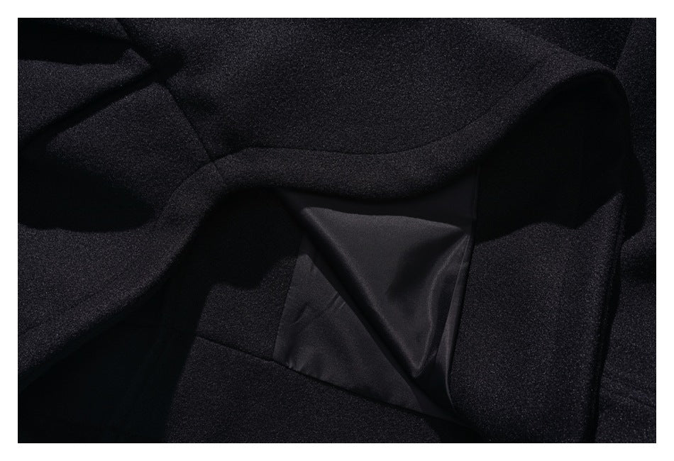 Close-up of a black garment interior showing a smooth lining panel and surrounding seams.