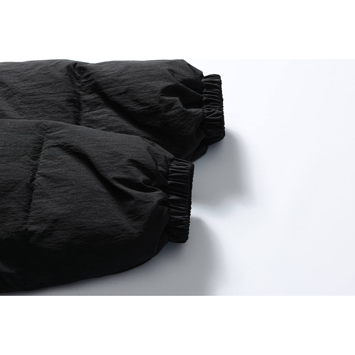 Close-up of two black jacket sleeves showing gathered elastic cuffs.