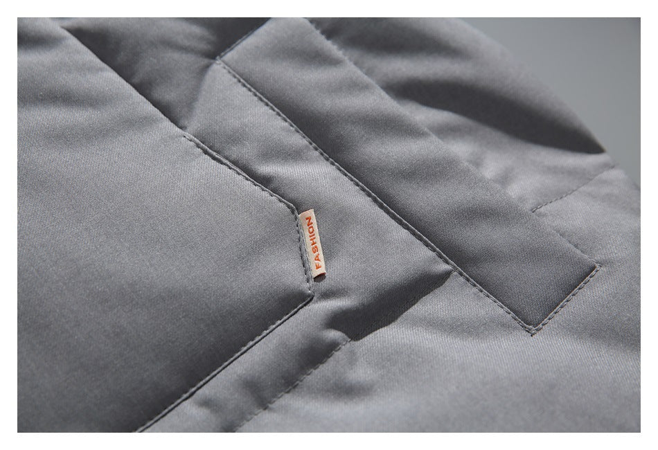 Close-up of a gray jacket pocket seam with a small FASHION tag.