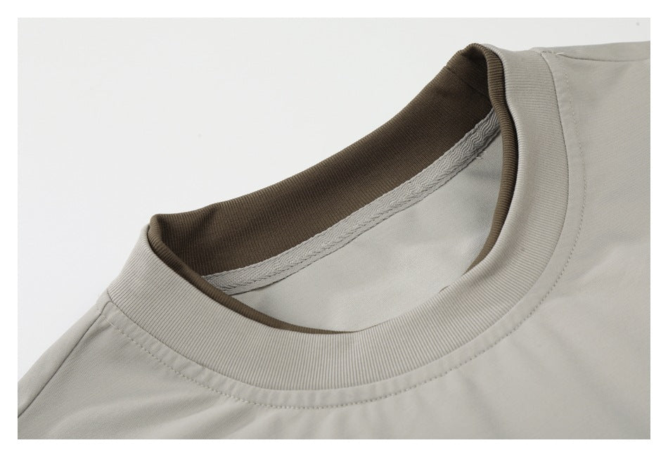 Close-up of the light gray T-shirt's ribbed crew neck and darker brown inner collar.