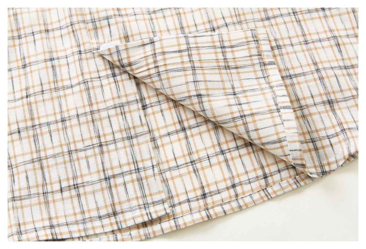 Close-up of the cream, tan, and dark plaid shirt hem with a folded section revealing the fabric.