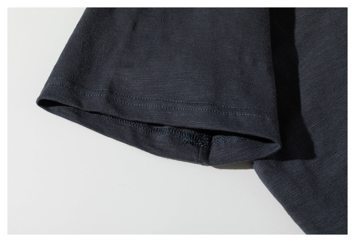 Close-up of the charcoal T-shirt's short sleeve, showing its double-stitched hem.