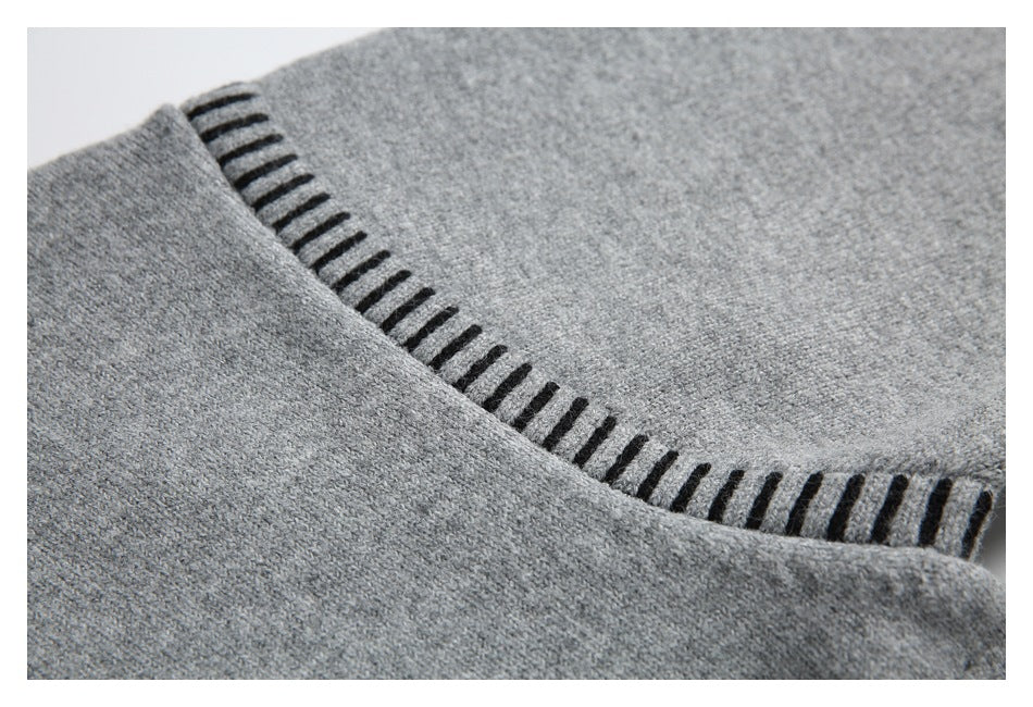 Close-up of gray knit fabric with a curved seam finished in black stitch accents.