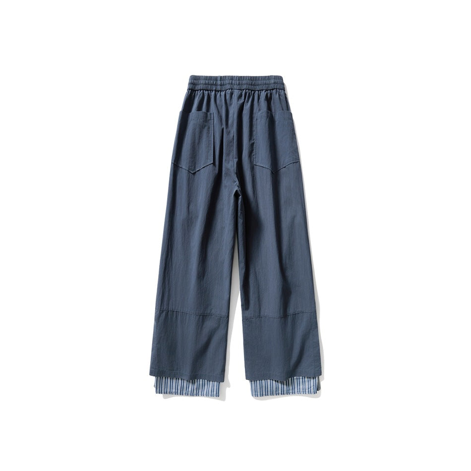Blue wide-leg pants back view with two patch pockets and a striped layered hem