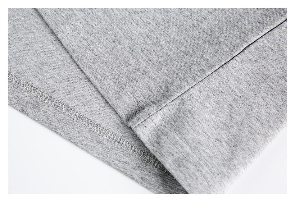 Close-up of the heather gray shirt's stitched hem and overlapping fabric.