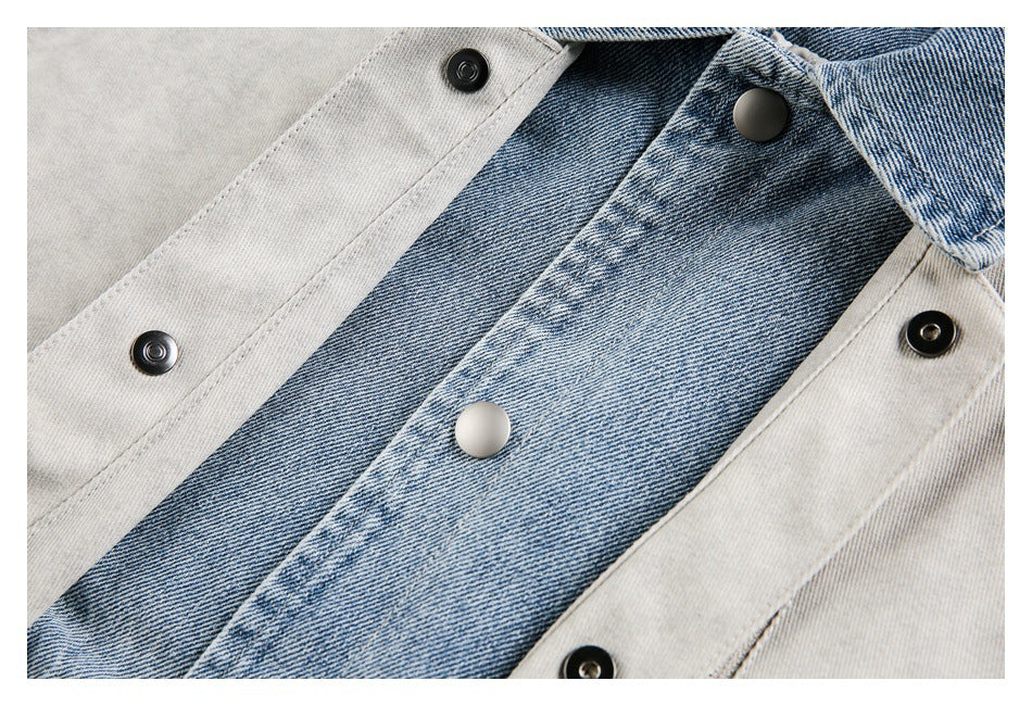 Close-up of blue denim and light gray jacket panels with contrasting snap buttons.