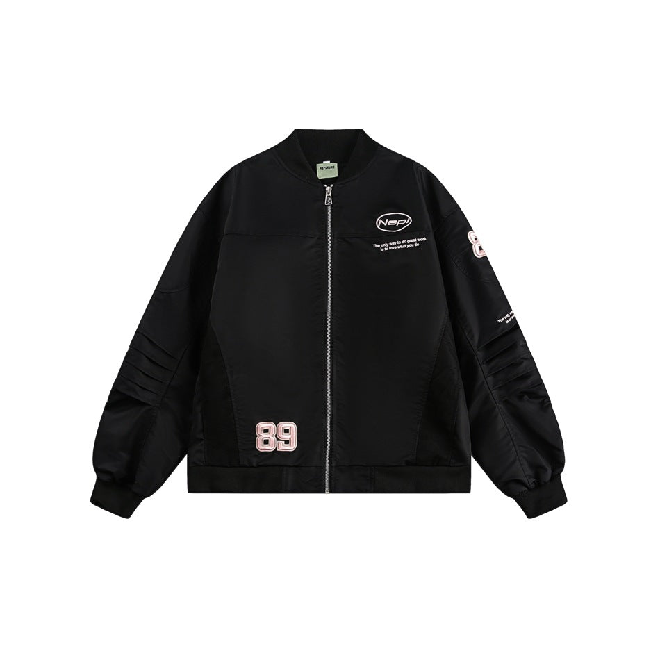 Black bomber jacket flat lay with silver zipper, pleated sleeves, ribbed trim and pink 89 patch