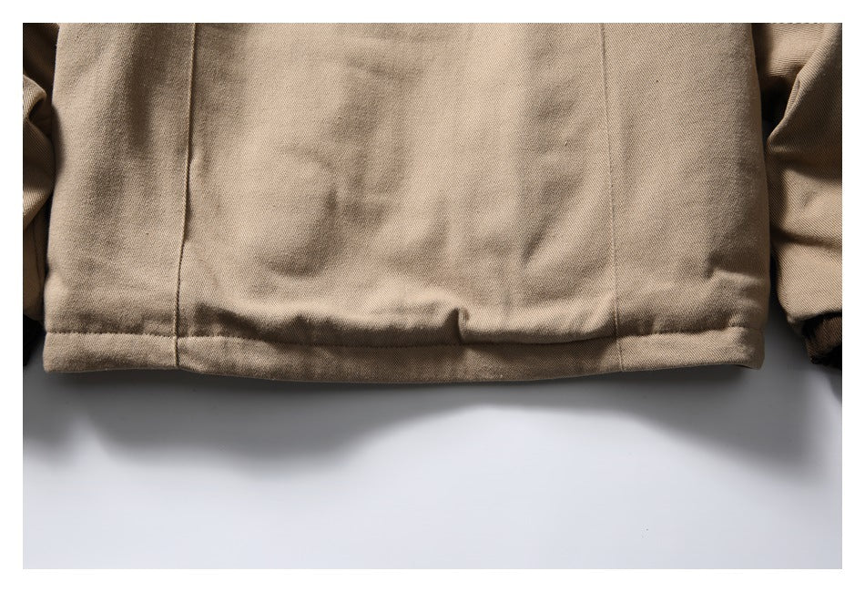 Close-up of the tan jacket's lower back hem and seam detailing.