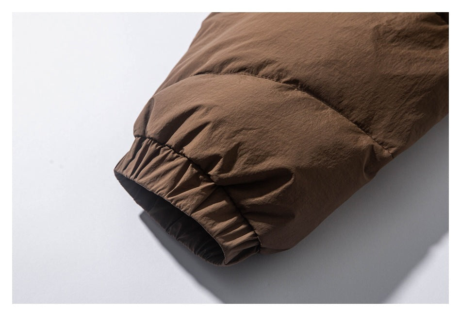 Close-up of a brown jacket sleeve ending in a gathered cuff with dark lining.