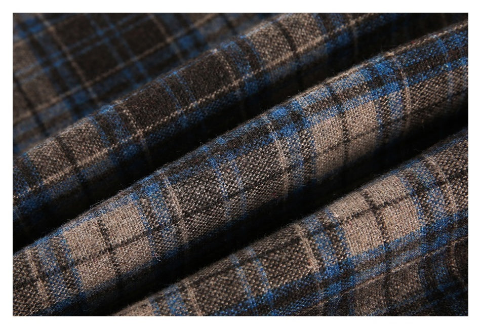 Macro view of the textured weave and blue lines in brown and charcoal plaid fabric.