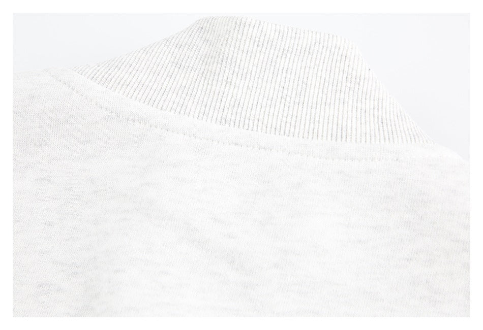 Close-up of a ribbed off-white garment edge meeting the body fabric.