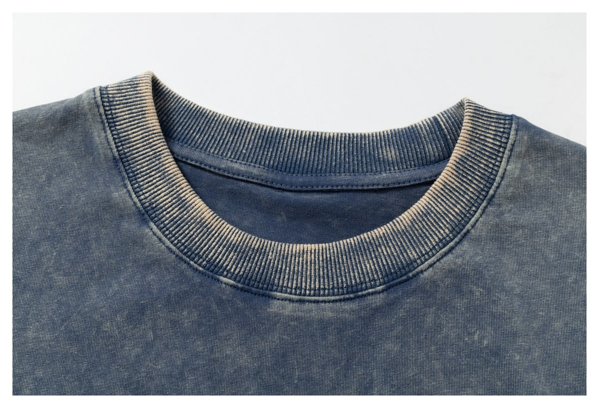 Close-up of a blue acid-wash shirt's ribbed crew neckline and shoulder area.