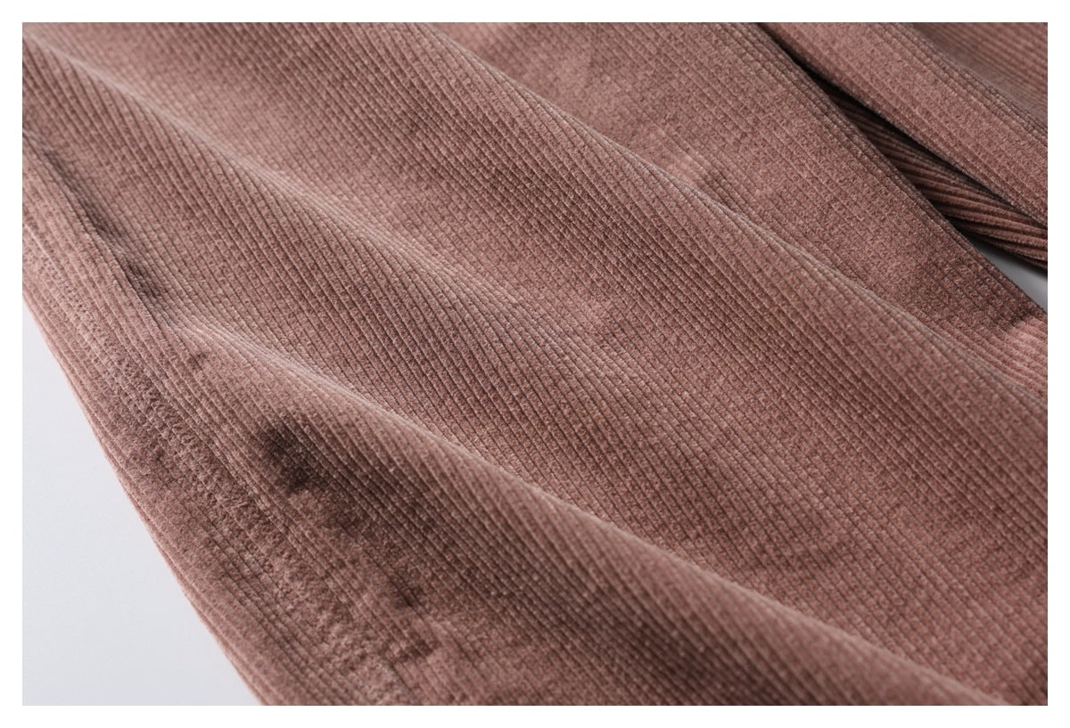 Close-up of dusty rose trousers showing the fine raised ribs and stitching along a seam.