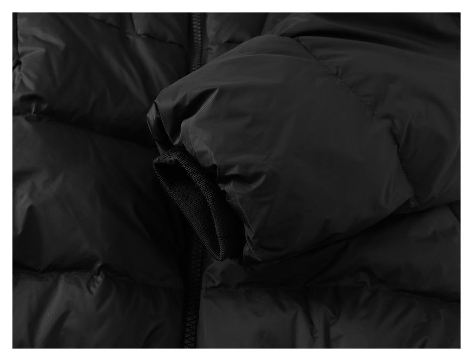 Close-up of a black jacket sleeve cuff with a fabric adjustment tab.