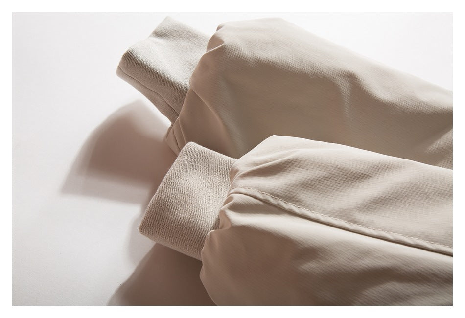 Close-up of the beige jacket's sleeves and wide ribbed cuffs, laid flat.