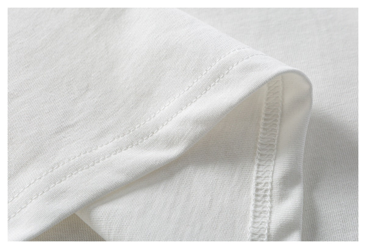 Close-up of a white garment hem with double stitching and an overlocked seam.