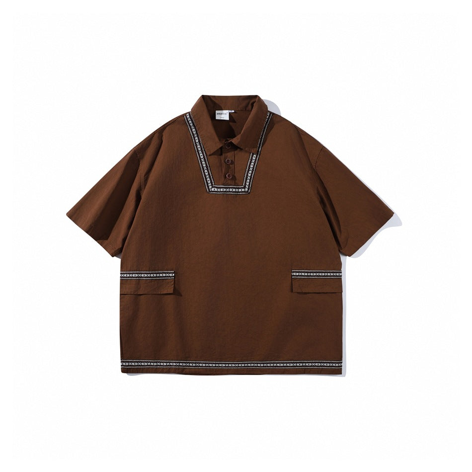Brown short-sleeve pullover shirt with collar, two buttons, woven geometric trim and flap pockets, flat lay