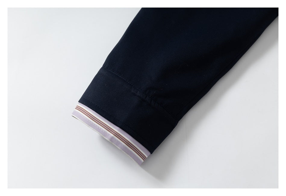 Close-up of a navy sleeve cuff with lavender, brown, and white striped lining at the edge.