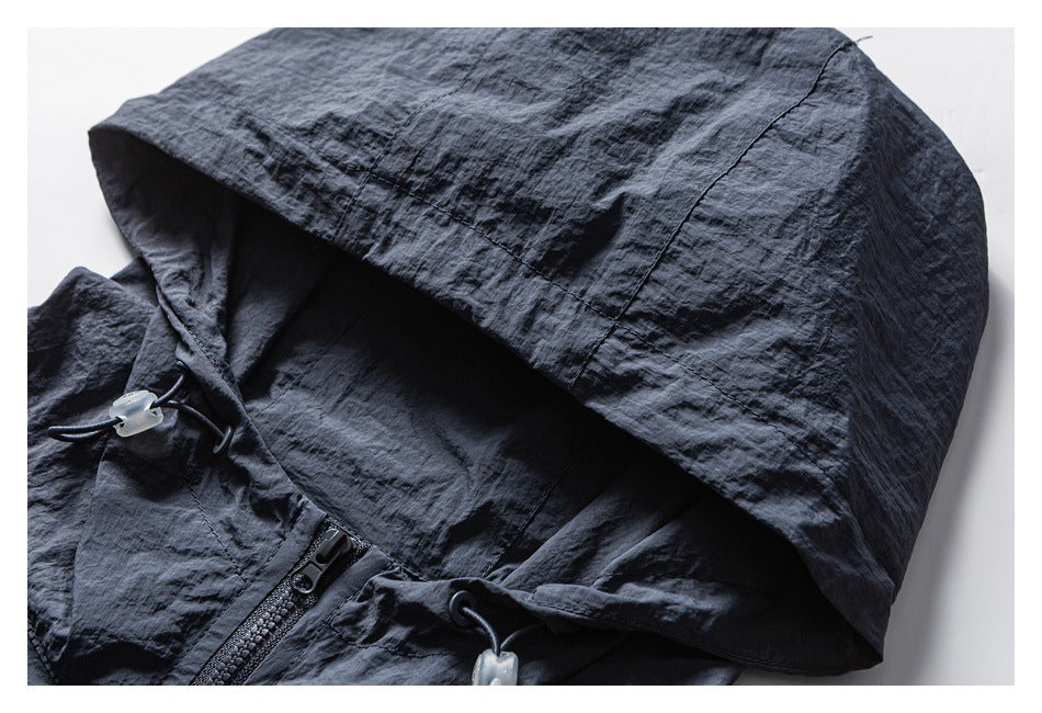 Close-up of a dark jacket hood with a front zipper and adjustable drawcords.