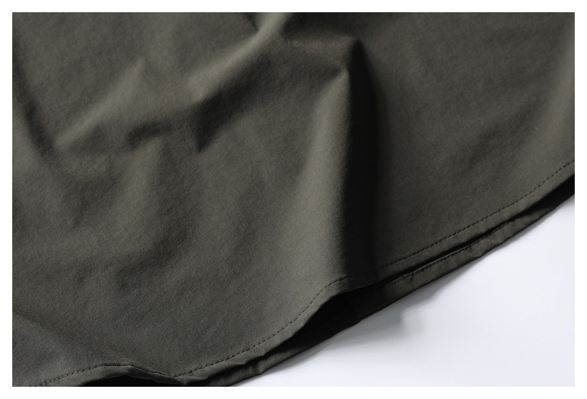 Close-up of the stitched hem on a dark olive garment.