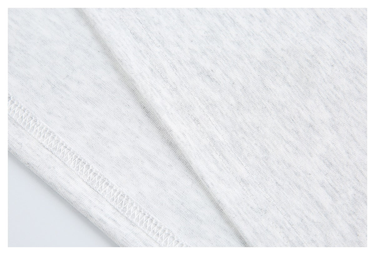 Close-up of a white heathered knit garment showing an overlocked seam.