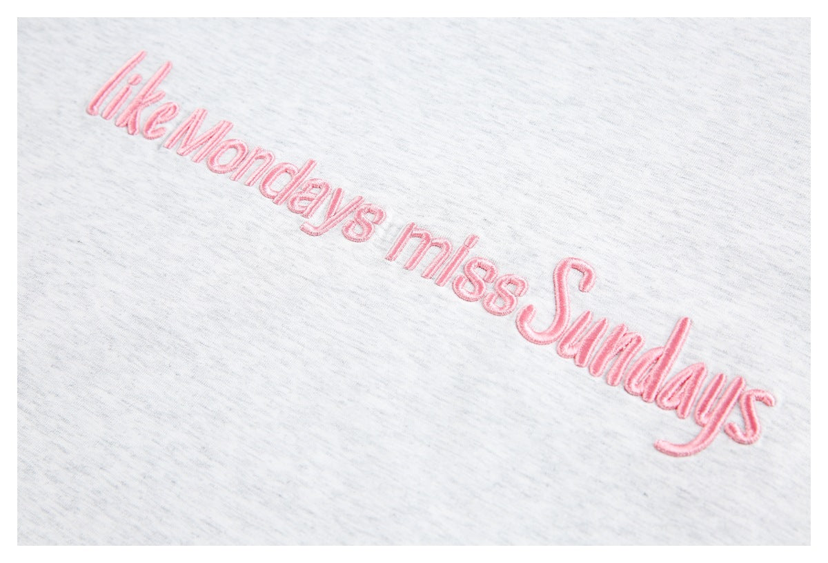 Pink embroidered “like Mondays miss Sundays” lettering on a light gray heather T-shirt.