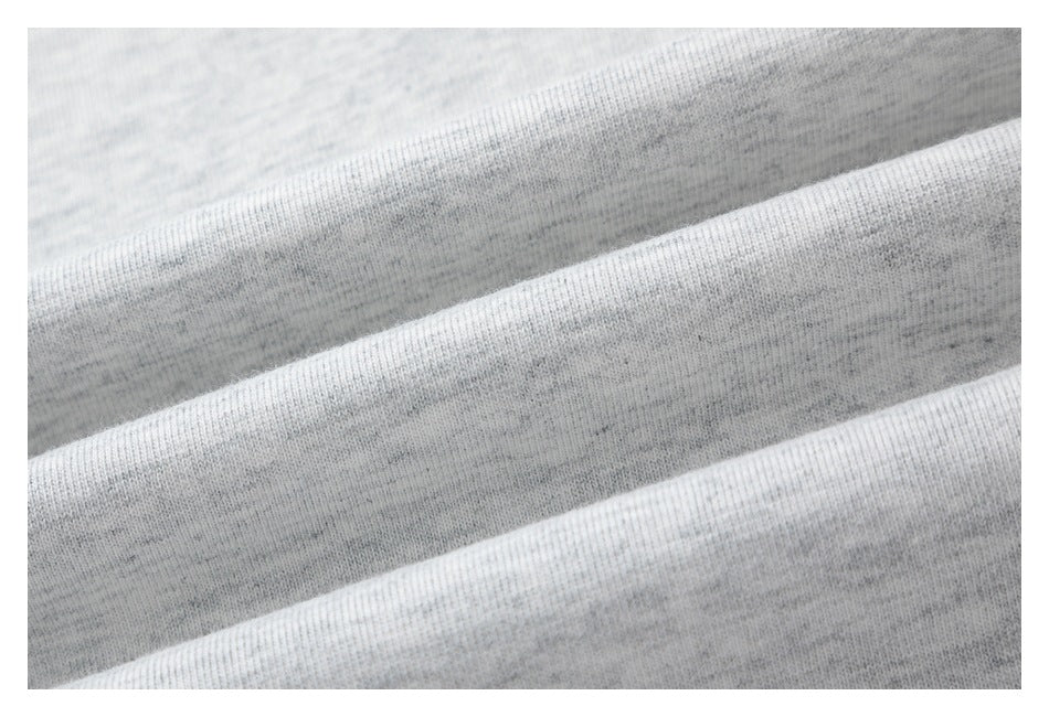 Close-up of folds showing the heathered knit texture of light gray T-shirt fabric.