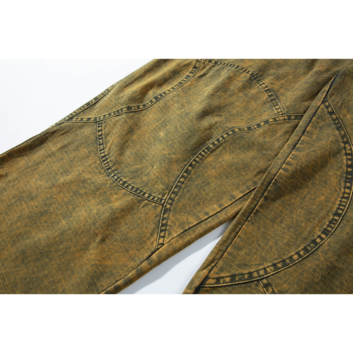 Close-up of ochre-brown trousers showing curved pocket and panel stitching on the back.