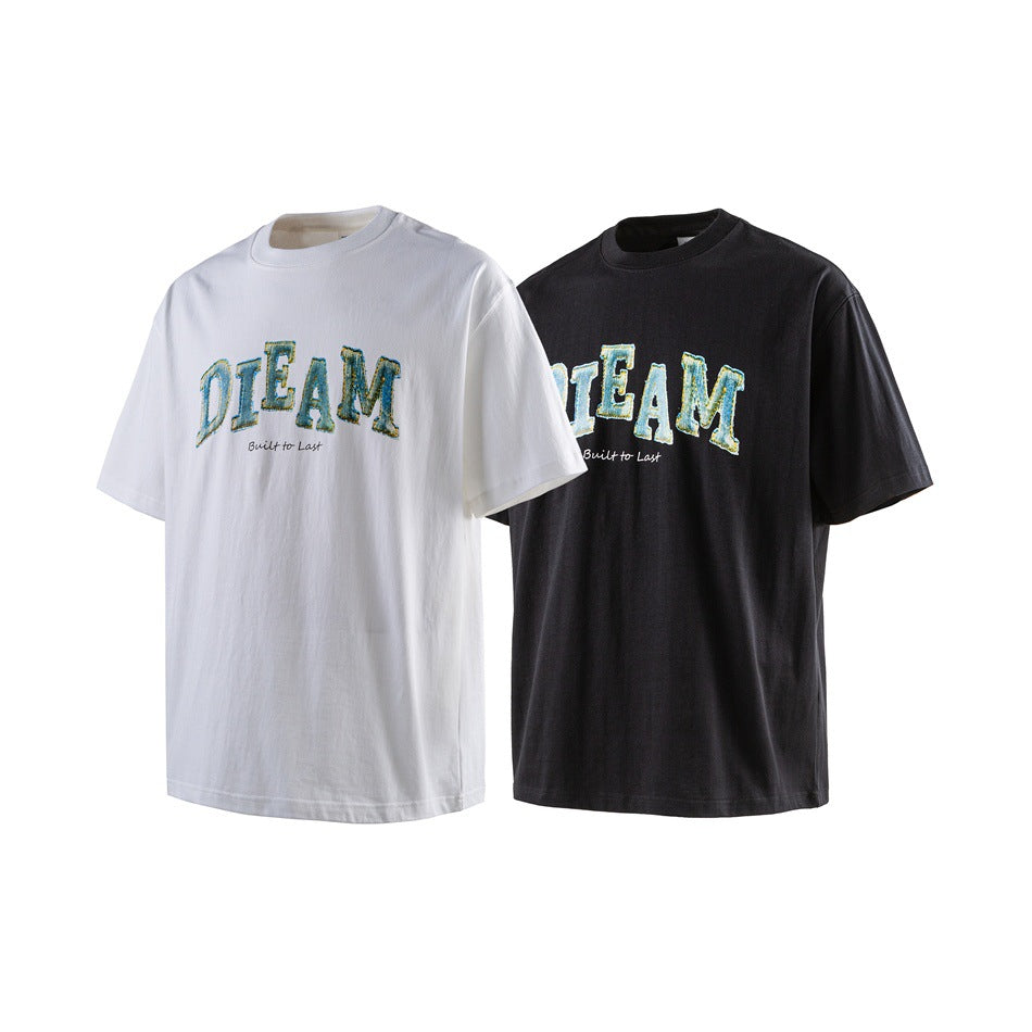 White and black short-sleeve crew-neck T-shirts with matching blue-and-yellow “DREAM” chest graphics.