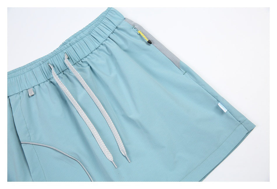 Angled close-up of the light blue skort showing its drawstrings, elastic waist, and gray-trimmed zip pocket.