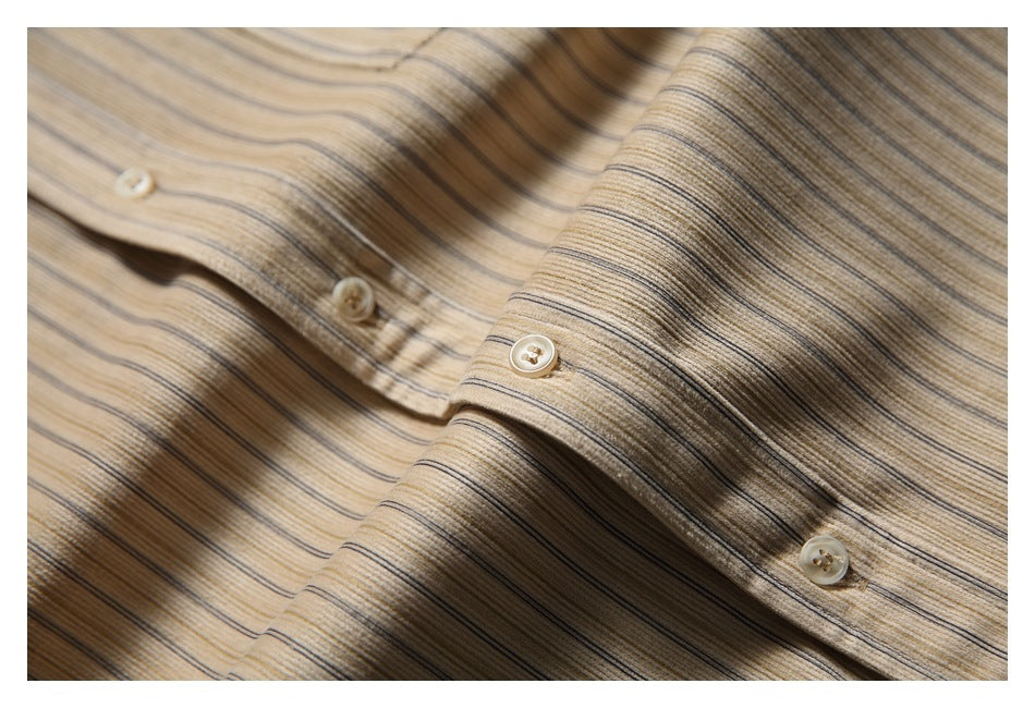Close-up of a beige shirt with fine brown and gray stripes and cream buttons along the placket.