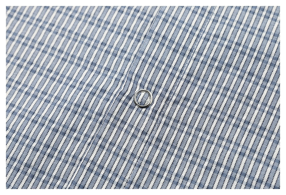 Close-up of blue-and-white checked shirt fabric, button, and placket stitching.