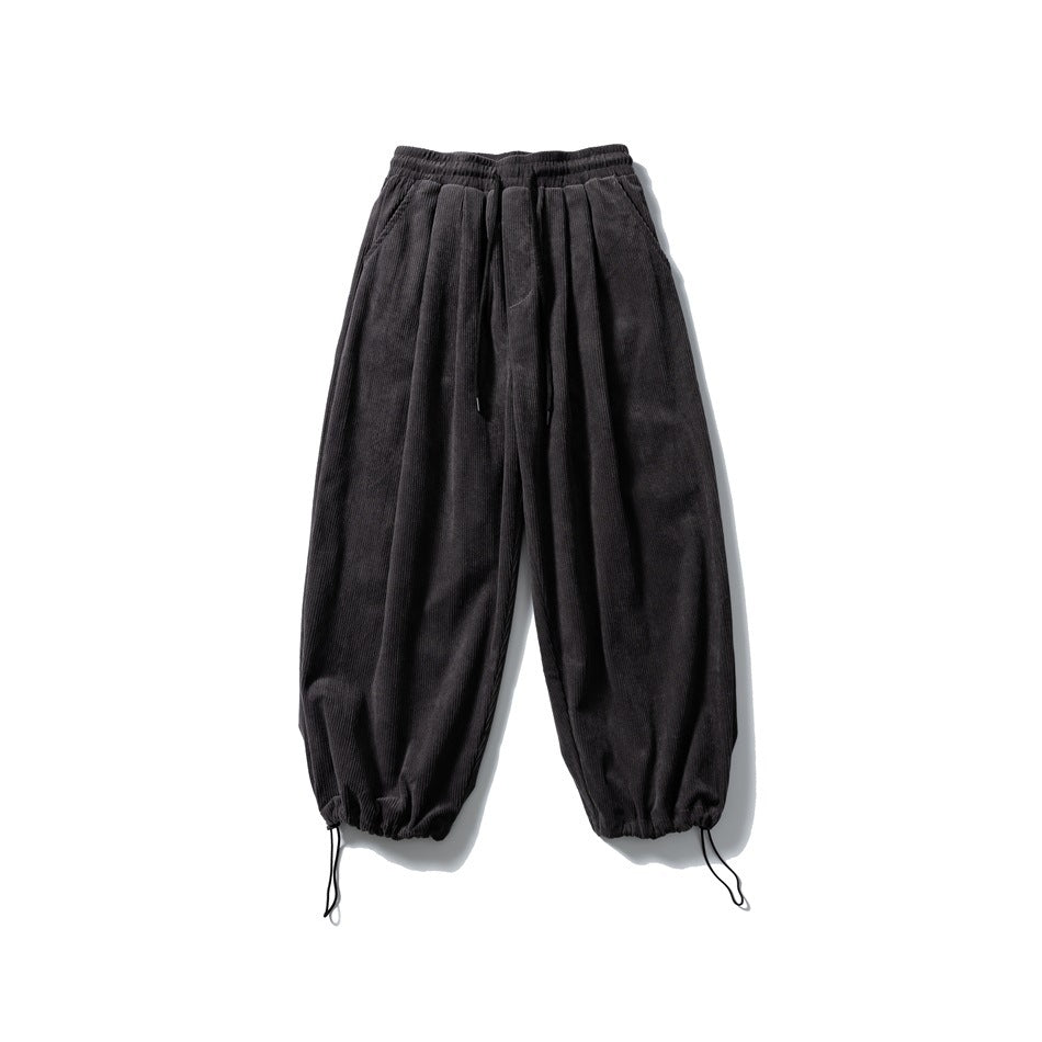 Dark gray corduroy wide-leg pants with the hem drawstrings cinched into a gathered ankle, flat lay front view