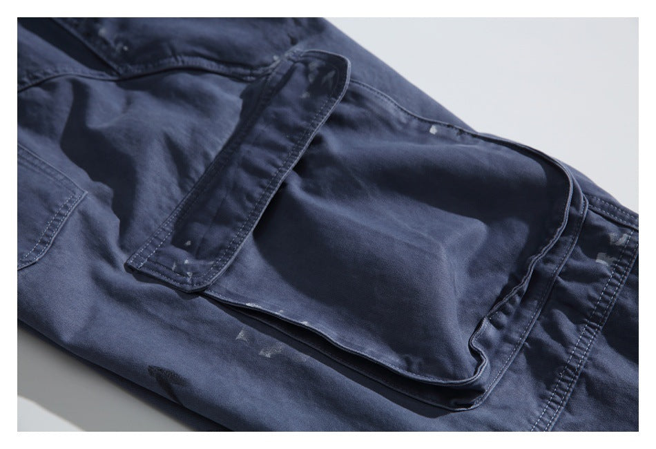 Close-up of a large flap cargo pocket on dark navy trousers.