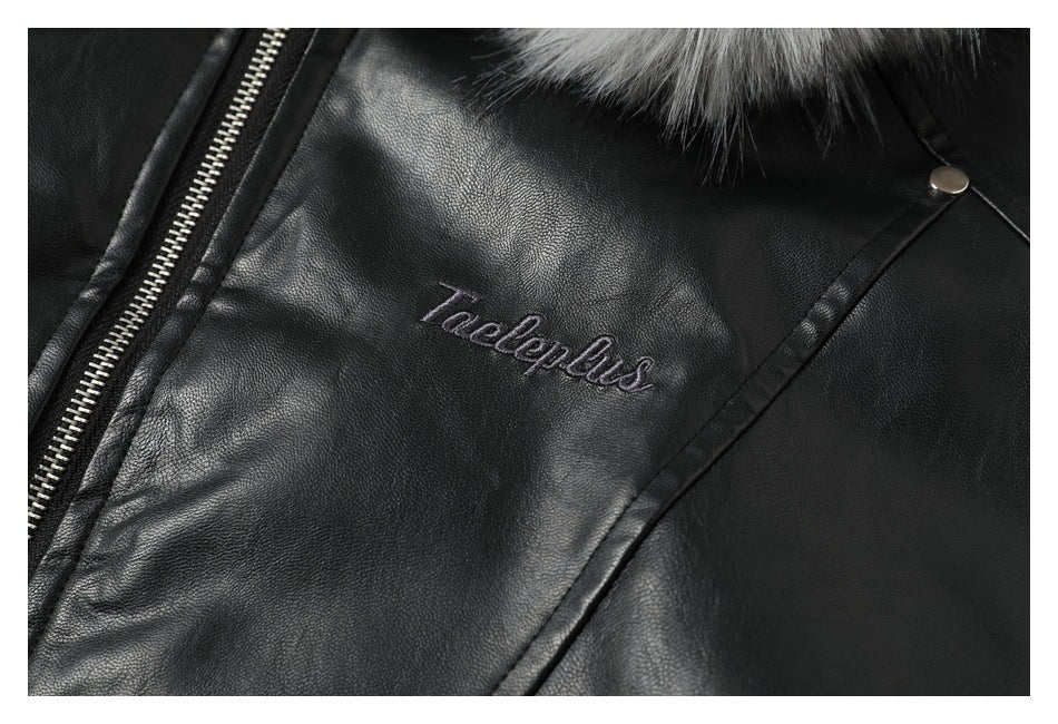 Close-up of stitched lettering on the black jacket chest, with the zipper and gray fur trim partly visible.