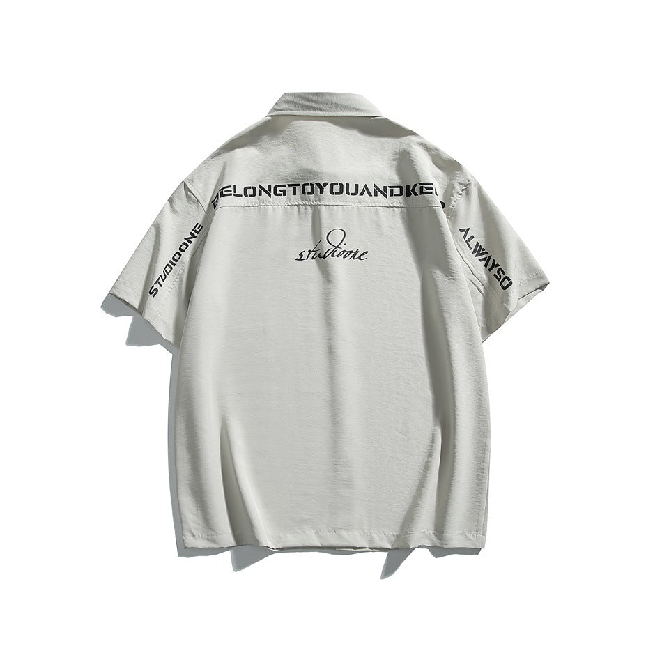 Back view of a light gray short-sleeve collared shirt with black lettering across the yoke and sleeves.